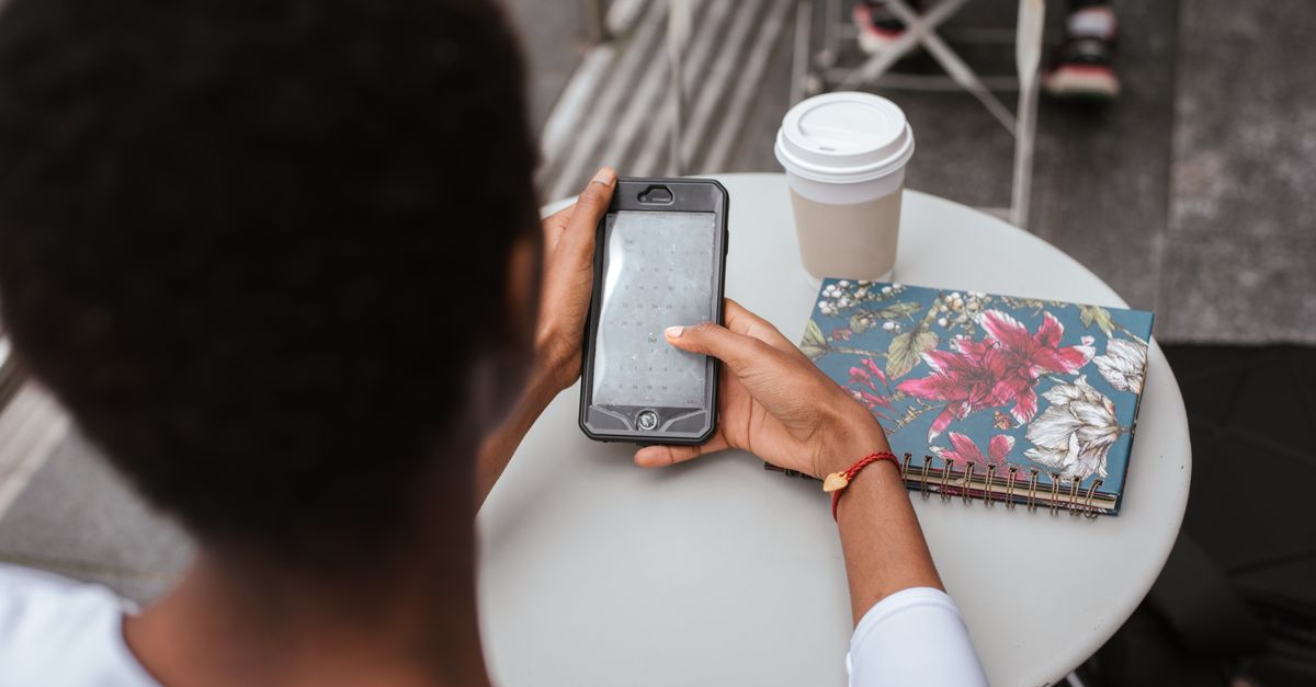 person typing phone cafe